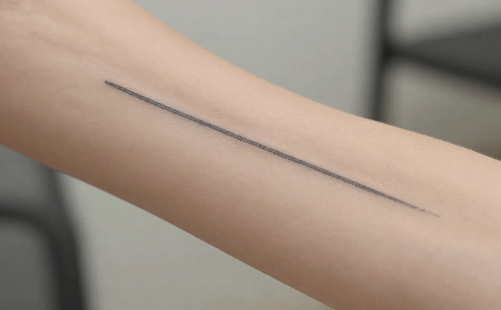 Egen fine-line tatueringsdesign förhandsgranskad på en underarm innan bokning